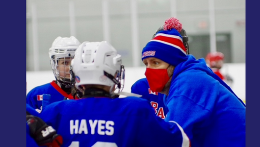 Gerry Hayes at the rink coaching three young hockey players.