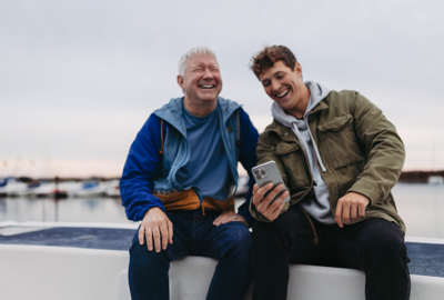 father and son looking at a phone laughing
