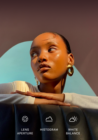 Close-up portrait of a well-lit model with a colourful background, demonstrating the pro camera system's Pro controls UI: Aperture, Histogram, White Balance